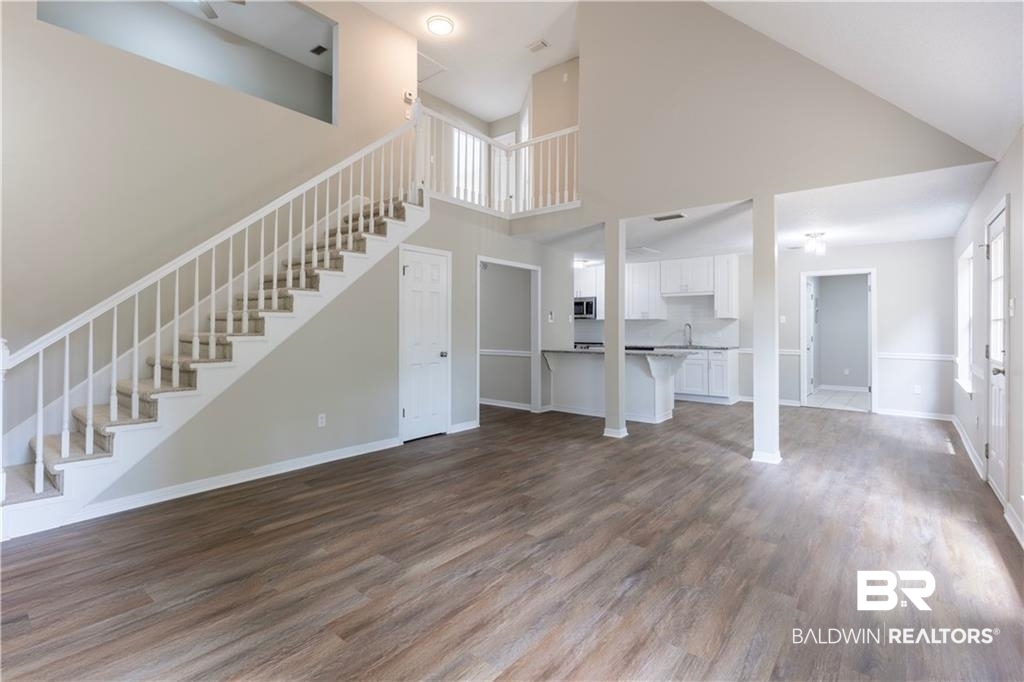 101 Lawson Road Daphne, AL 36526 - Photo 11 of 20 Spacious living area featuring wood-finish flooring and a staircase with white balusters