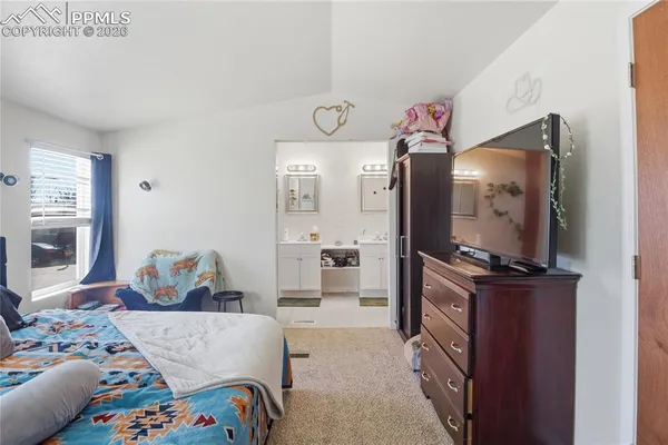 a bedroom with a bed and dresser with mirror