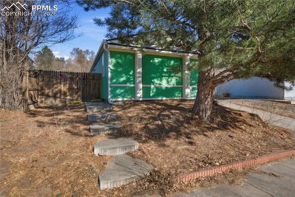 a view of a backyard with floor to ceiling window and tree