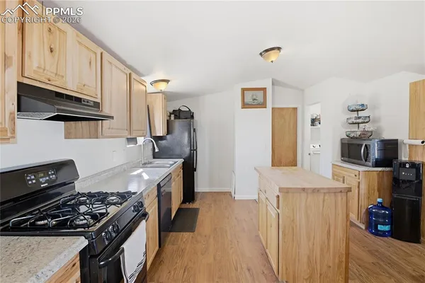 a kitchen with a stove and a wooden floor
