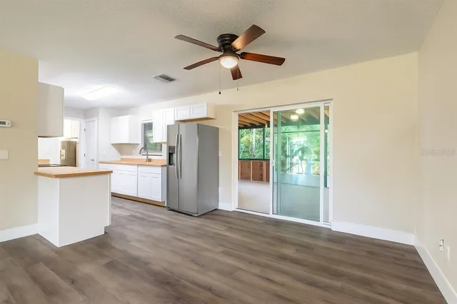 a view of kitchen with stainless steel appliances wooden floor and window