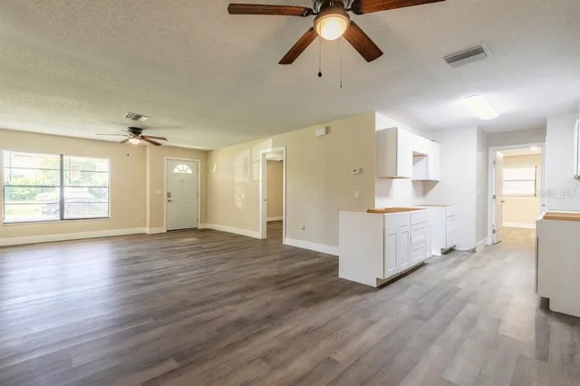 a view of empty room with wooden floor and window