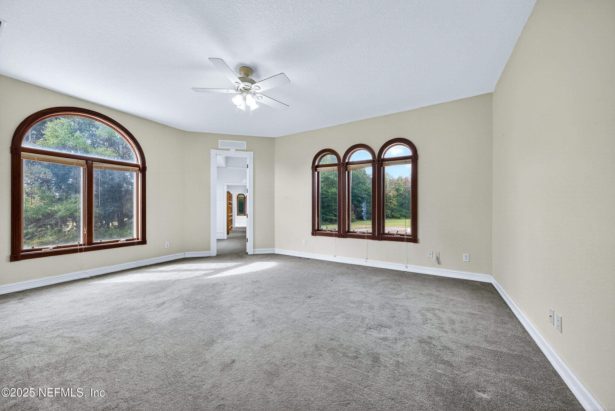 45500 Stratton Road Callahan, FL 32011 - Photo 19 of 58 an empty room with large windows and a ceiling fan