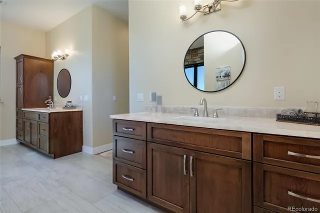 a en suite bathroom with a double vanity sink and a mirror