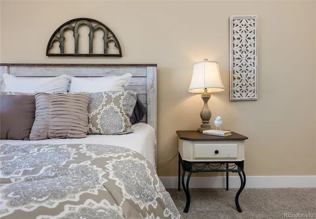 a bedroom with a bed and a table lamp