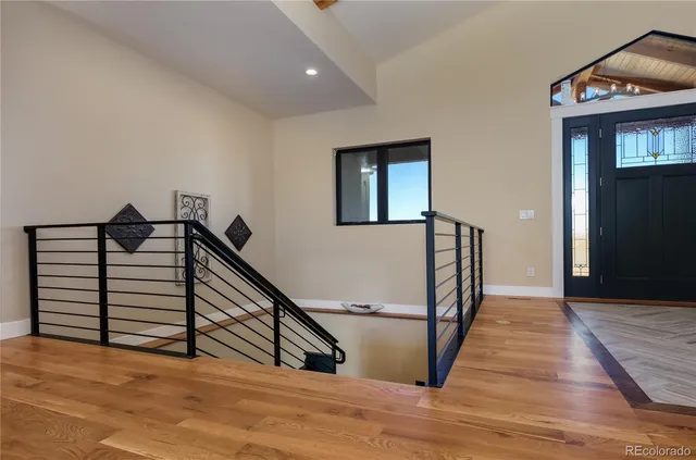 a view of a hallway with wooden floor and stairs