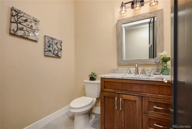 a bathroom with a toilet sink vanity and mirror
