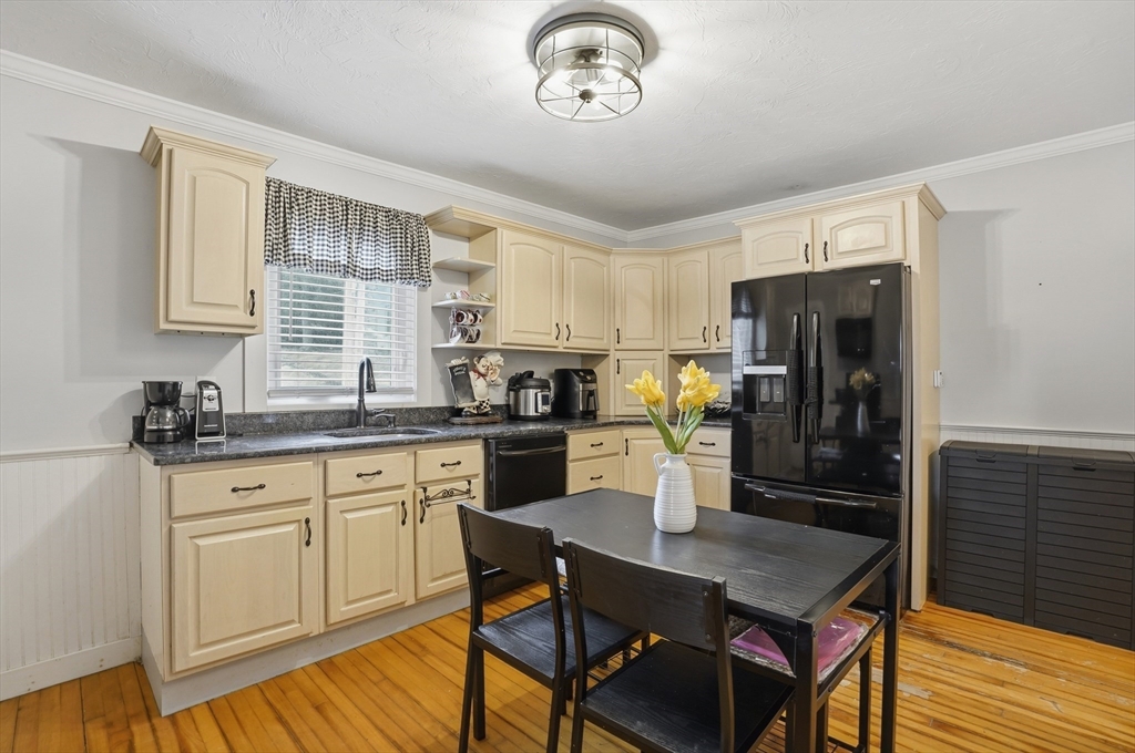 23 Dryden Street Worcester, MA 01605 - Photo 9 of 29 a kitchen with a refrigerator a stove a sink dishwasher with a dining table and chair