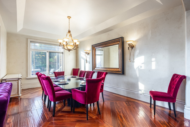 694 West Cephus Road Draper, UT 84020 - Photo 23 of 148 Dining space featuring wood-finish flooring, a large window, decorative wall sconces, and a tray ceiling