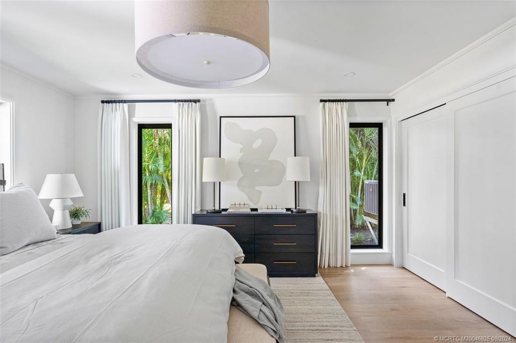 9 Mandalay Road Stuart, FL 34996 - Photo 36 of 44 a bedroom with a bed and a chandelier