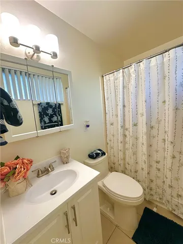 a bathroom with a sink a toilet and shower curtain