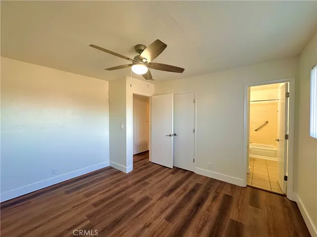 a view of a room with wooden floor and a ceiling fan