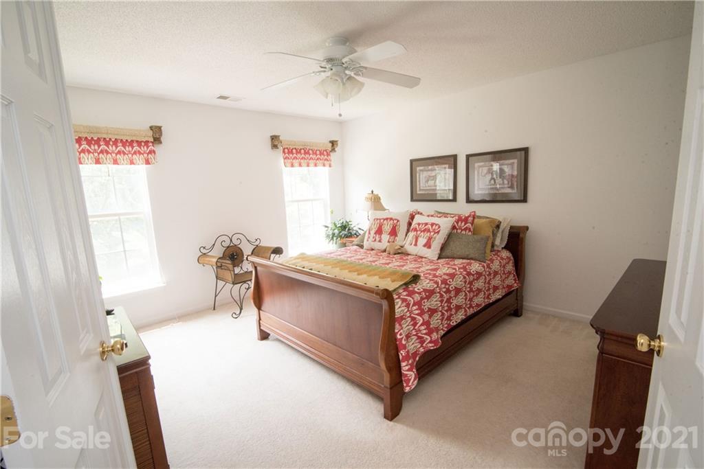 11427 Gold Pan Road Charlotte, NC 28215 - Photo 17 of 34 a bedroom with a bed and a chandelier
