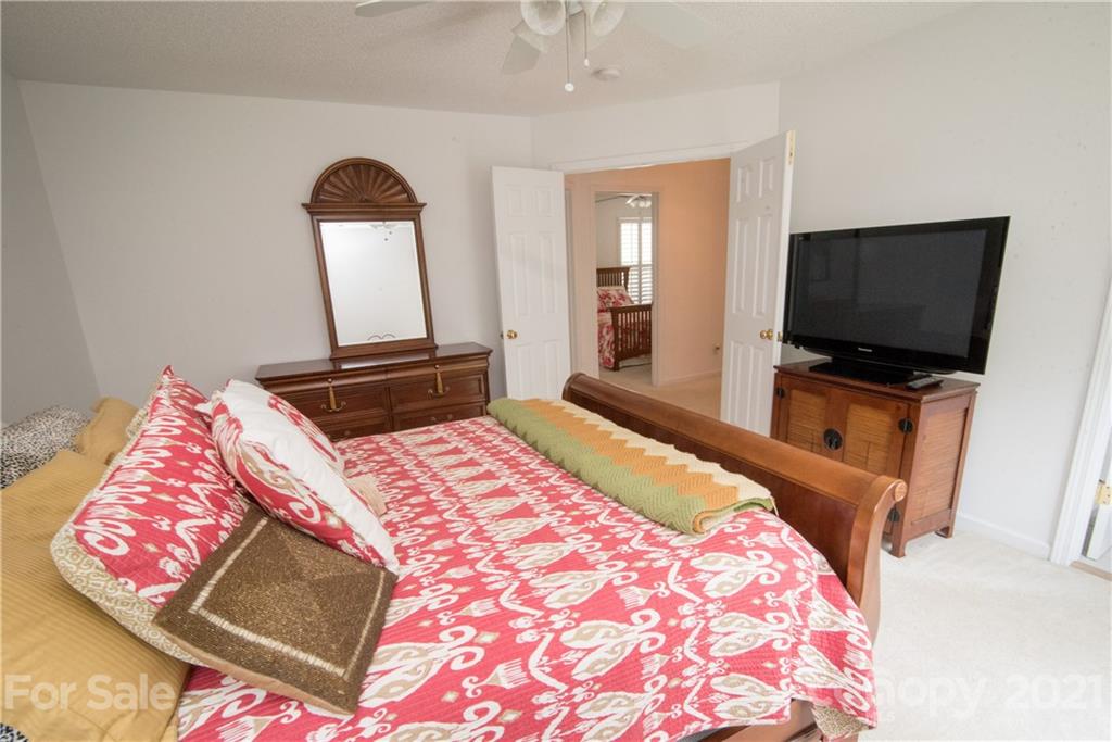 11427 Gold Pan Road Charlotte, NC 28215 - Photo 18 of 34 a bedroom with a bed and a flat screen television