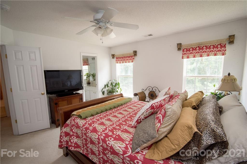 11427 Gold Pan Road Charlotte, NC 28215 - Photo 19 of 34 a bedroom with a bed and a flat screen tv