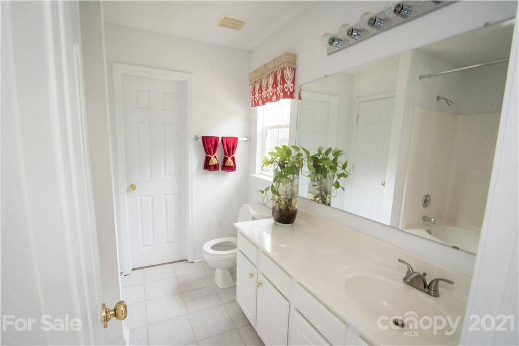 11427 Gold Pan Road Charlotte, NC 28215 - Photo 20 of 34 a bathroom with a sink a toilet and a shower curtain