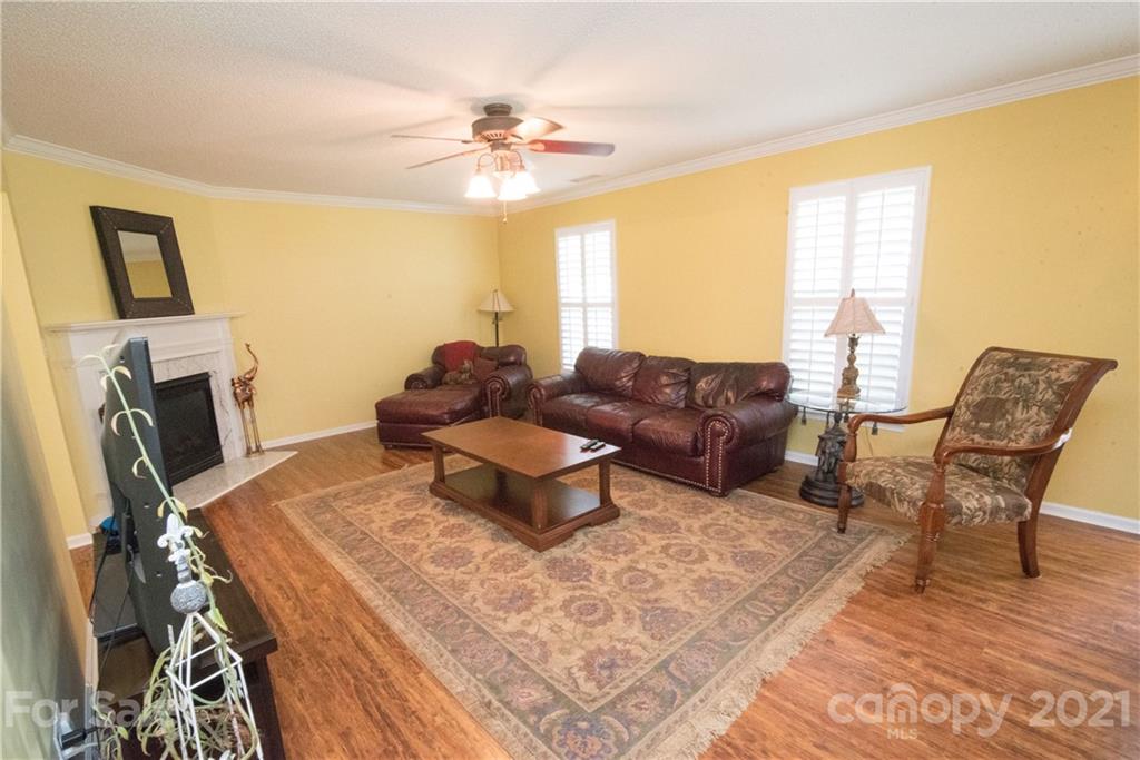 11427 Gold Pan Road Charlotte, NC 28215 - Photo 7 of 34 a living room with furniture a fireplace and a flat screen tv