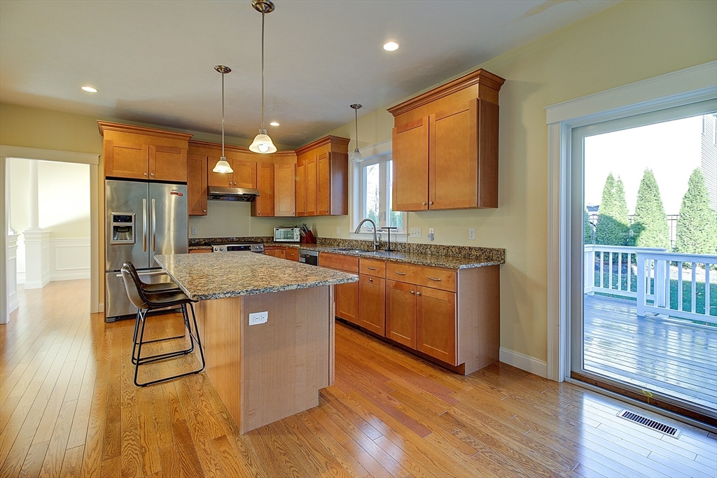 143 Potter Road Framingham, MA 01701 - Photo 14 of 42 a kitchen with kitchen island granite countertop wooden floors granite counter tops and a view of living room