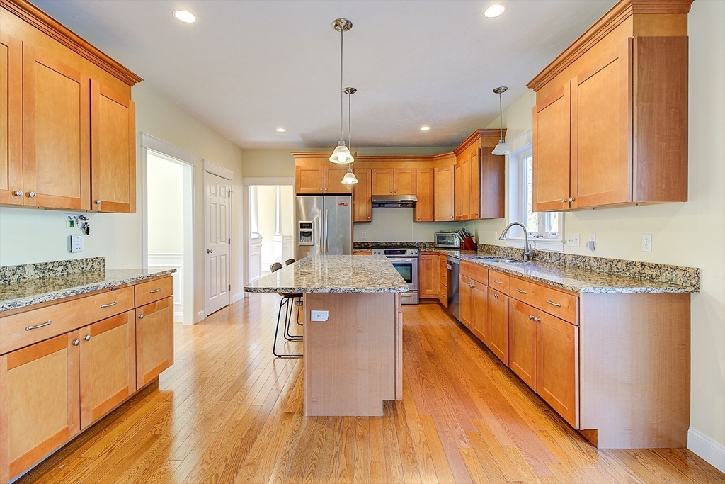 143 Potter Road Framingham, MA 01701 - Photo 16 of 42 a kitchen with stainless steel appliances granite countertop wooden floors and white cabinets
