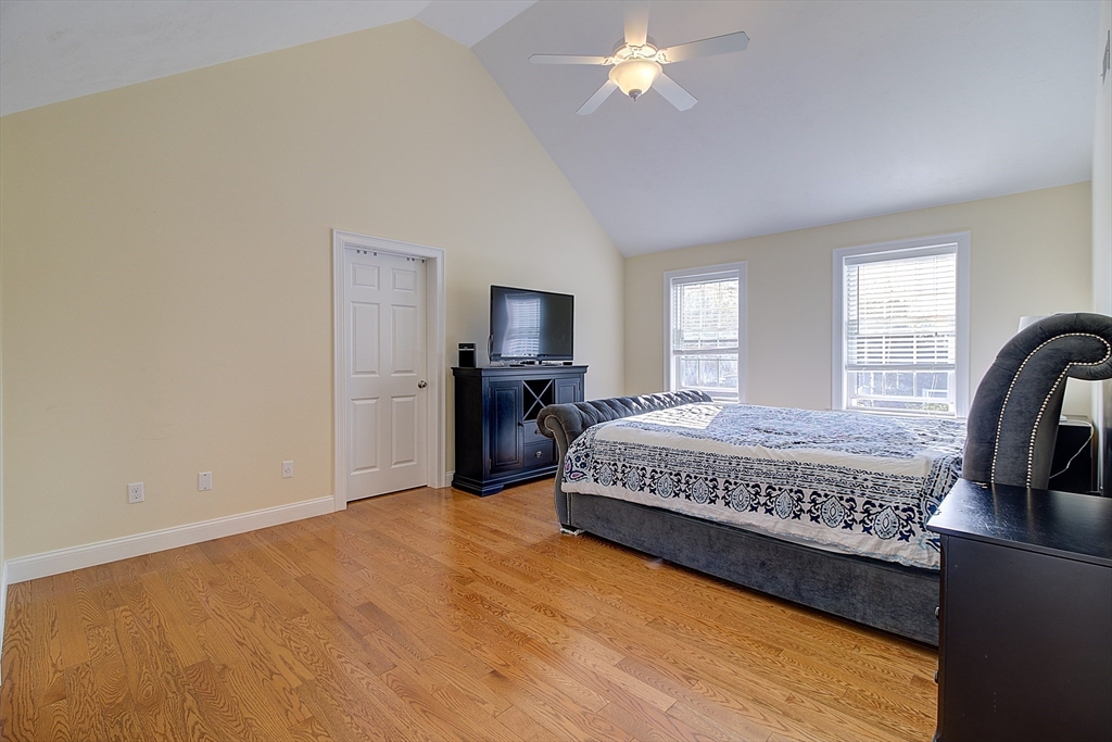 143 Potter Road Framingham, MA 01701 - Photo 24 of 42 a spacious bedroom with a bed and a chandelier