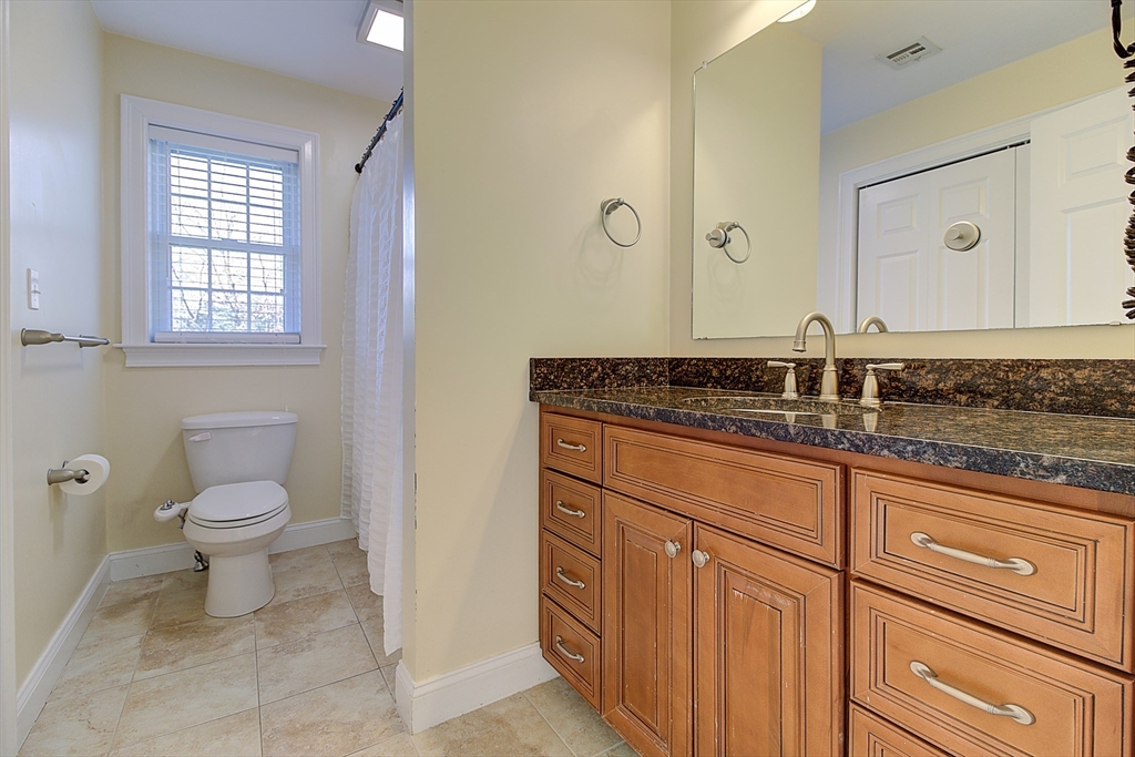 143 Potter Road Framingham, MA 01701 - Photo 33 of 42 a bathroom with a granite countertop toilet sink and mirror
