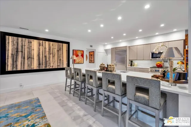 a kitchen with stainless steel appliances kitchen island granite countertop a dining table and chairs