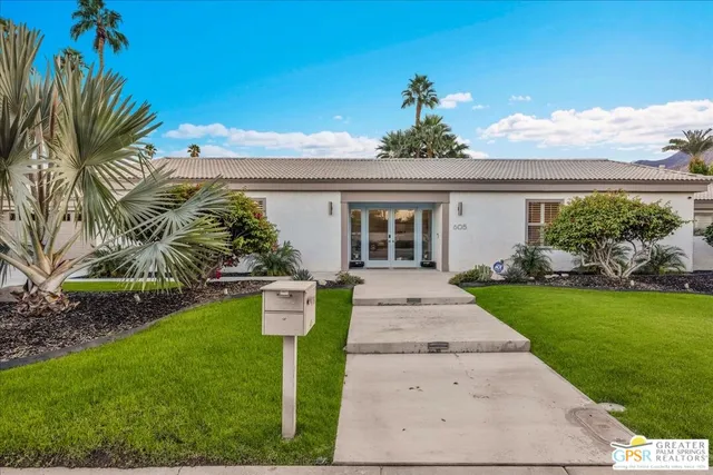 a front view of a house with a garden and yard