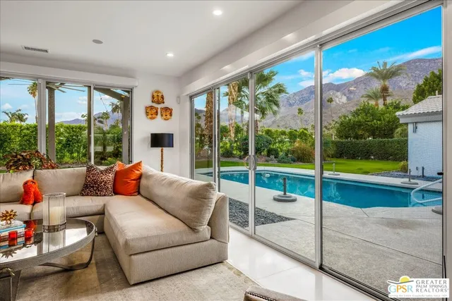 a living room with furniture and floor to ceiling windows