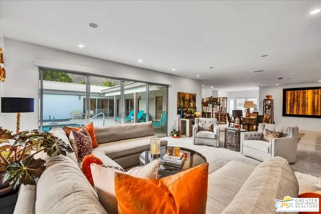 a dining room with furniture and a floor to ceiling window