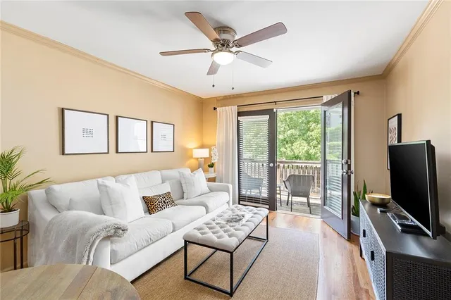 a living room with furniture a flat screen tv and a large window