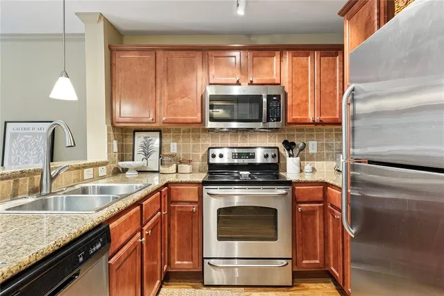 a kitchen with stainless steel appliances granite countertop a sink a stove and a microwave