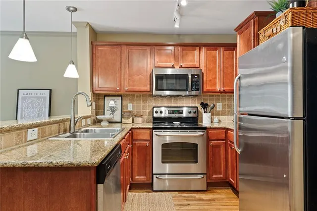 a kitchen with kitchen island granite countertop a sink stainless steel appliances and cabinets