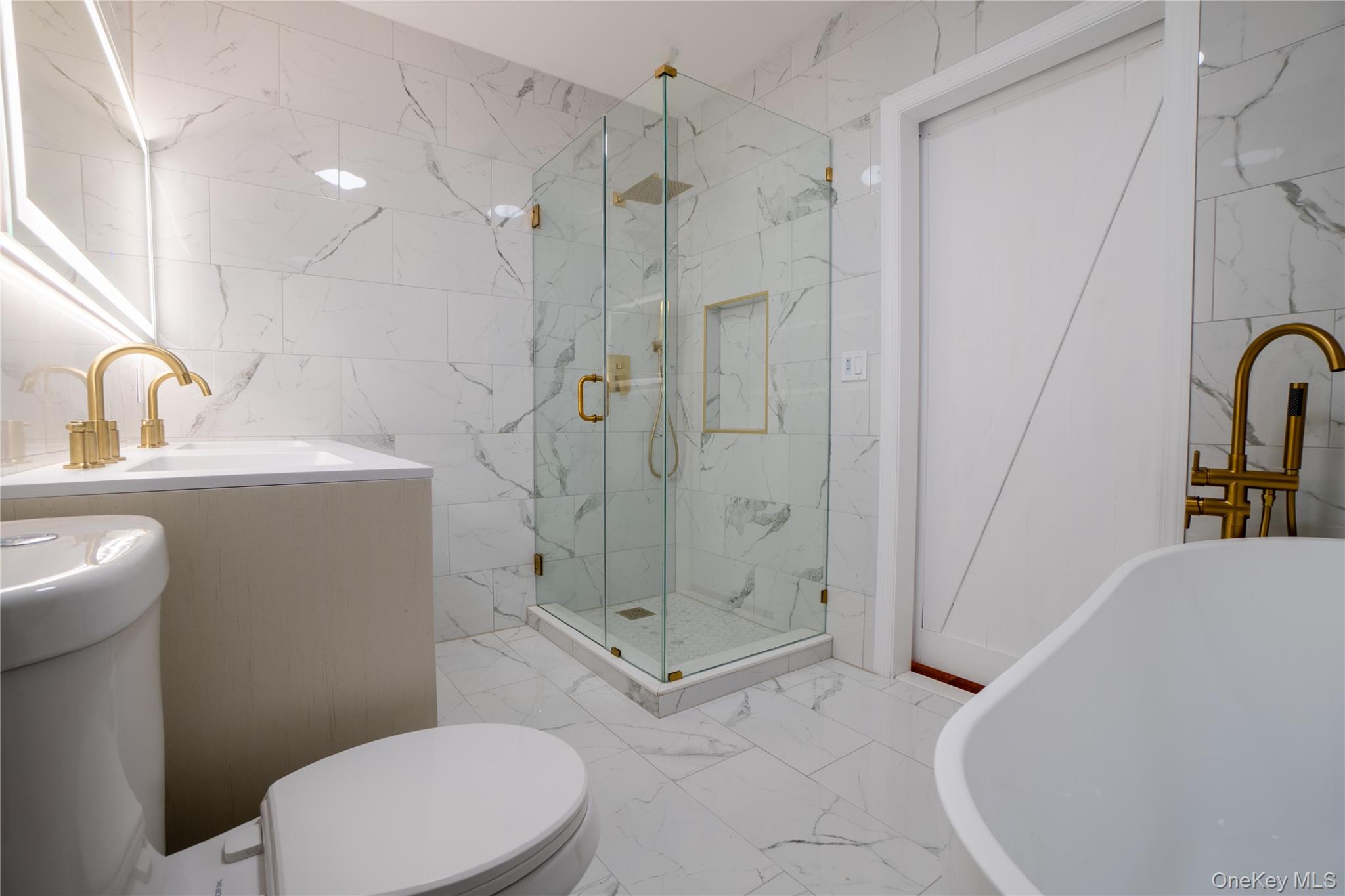 139 Maple Avenue Bethpage, NY 11714 - Photo 14 of 25 Full bath with tile walls, light marble finish floors, a soaking tub, a marble finish shower, and vanity
