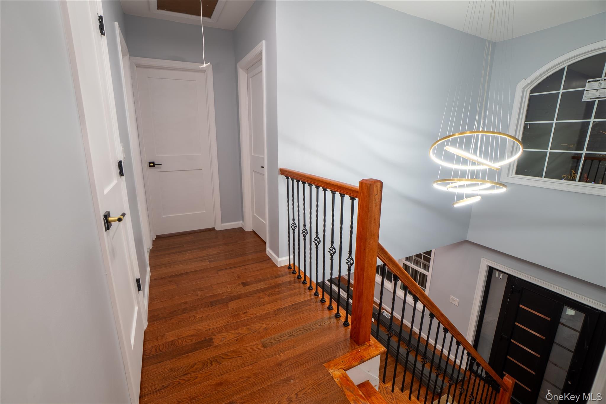 139 Maple Avenue Bethpage, NY 11714 - Photo 15 of 25 Hallway with dark wood-type flooring, a chandelier, attic access, stairs, and an upstairs landing