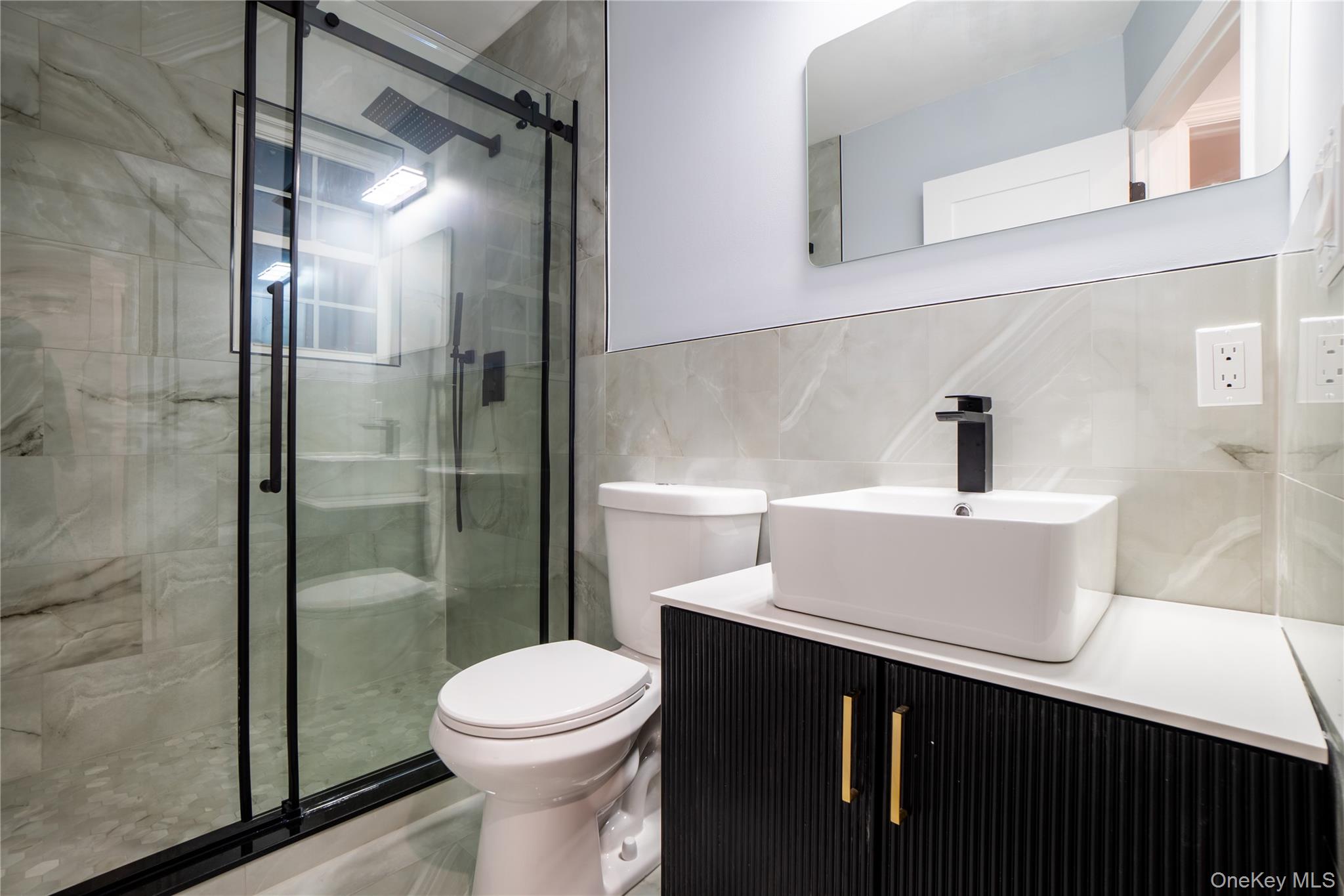 139 Maple Avenue Bethpage, NY 11714 - Photo 20 of 25 Full bathroom with tile walls, a shower stall, and vanity