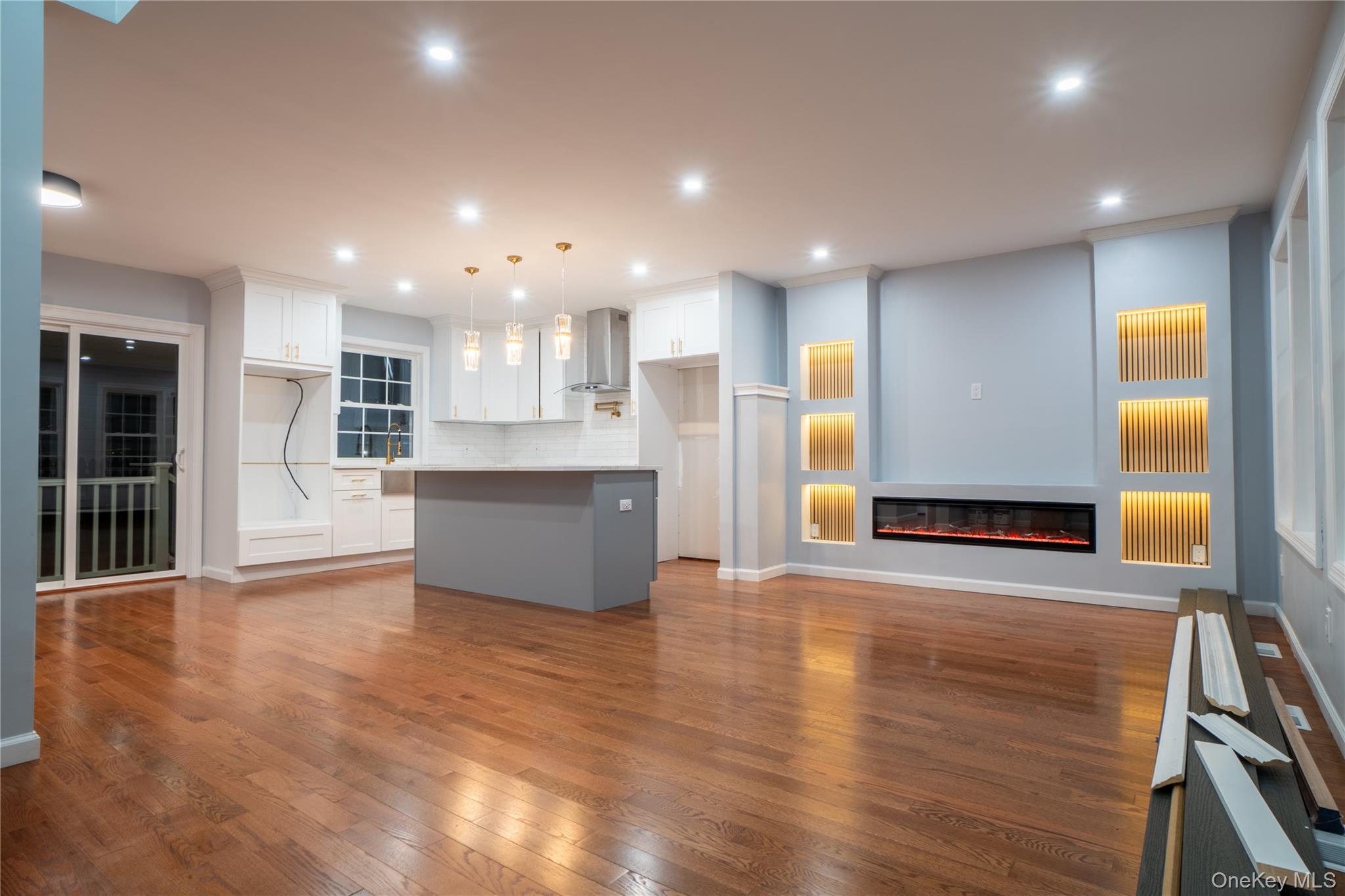 139 Maple Avenue Bethpage, NY 11714 - Photo 3 of 25 Unfurnished living room with a glass covered fireplace, dark wood-type flooring, and recessed lighting