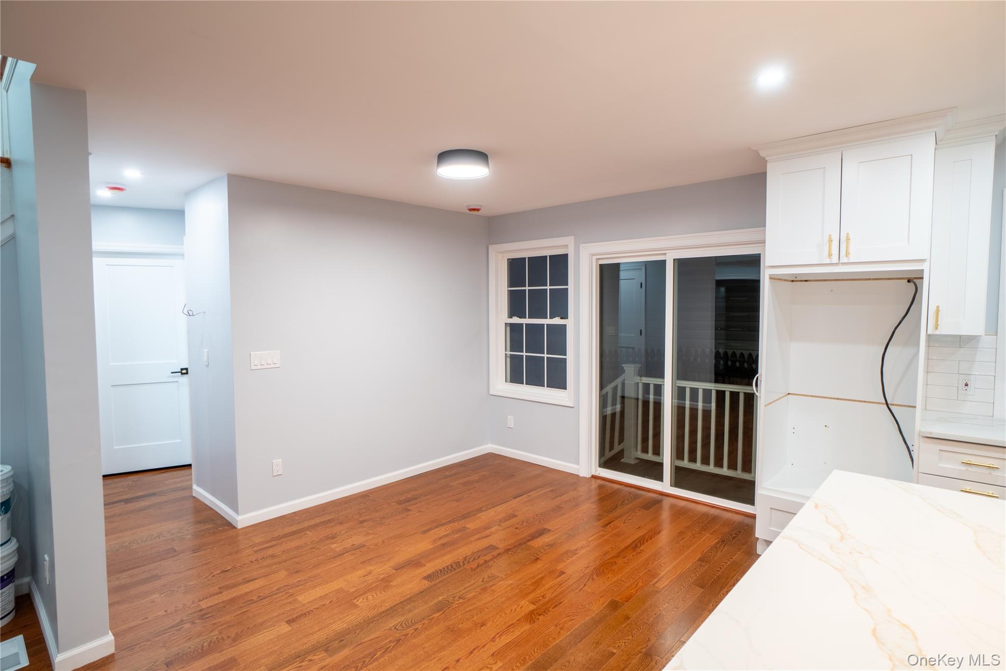 139 Maple Avenue Bethpage, NY 11714 - Photo 8 of 25 Kitchen featuring light stone countertops, white cabinetry, light wood-type flooring, recessed lighting, and backsplash