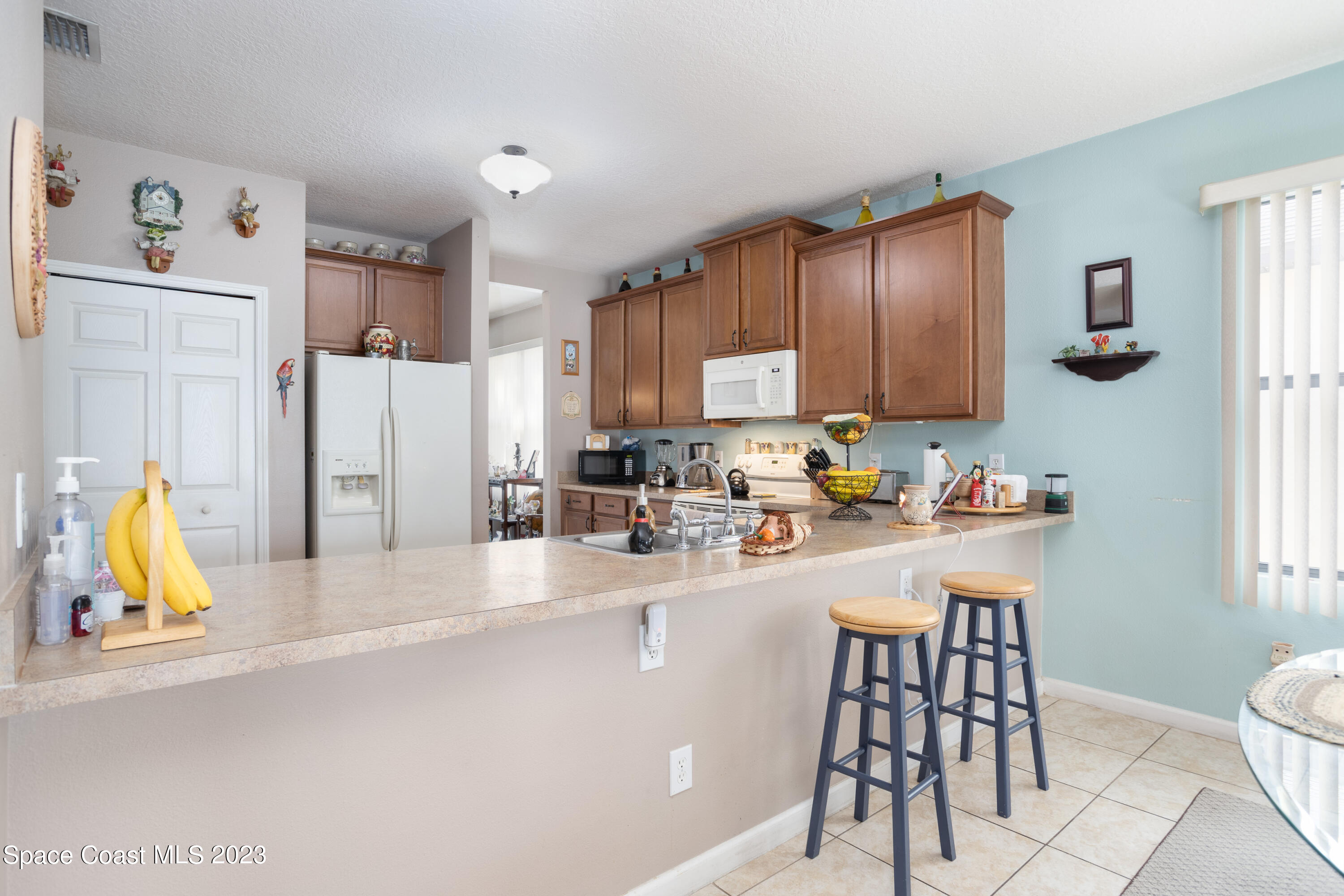 4130 Millicent Circle Melbourne, FL 32901 - Photo 12 of 28 a kitchen with stainless steel appliances granite countertop a refrigerator and a stove top oven