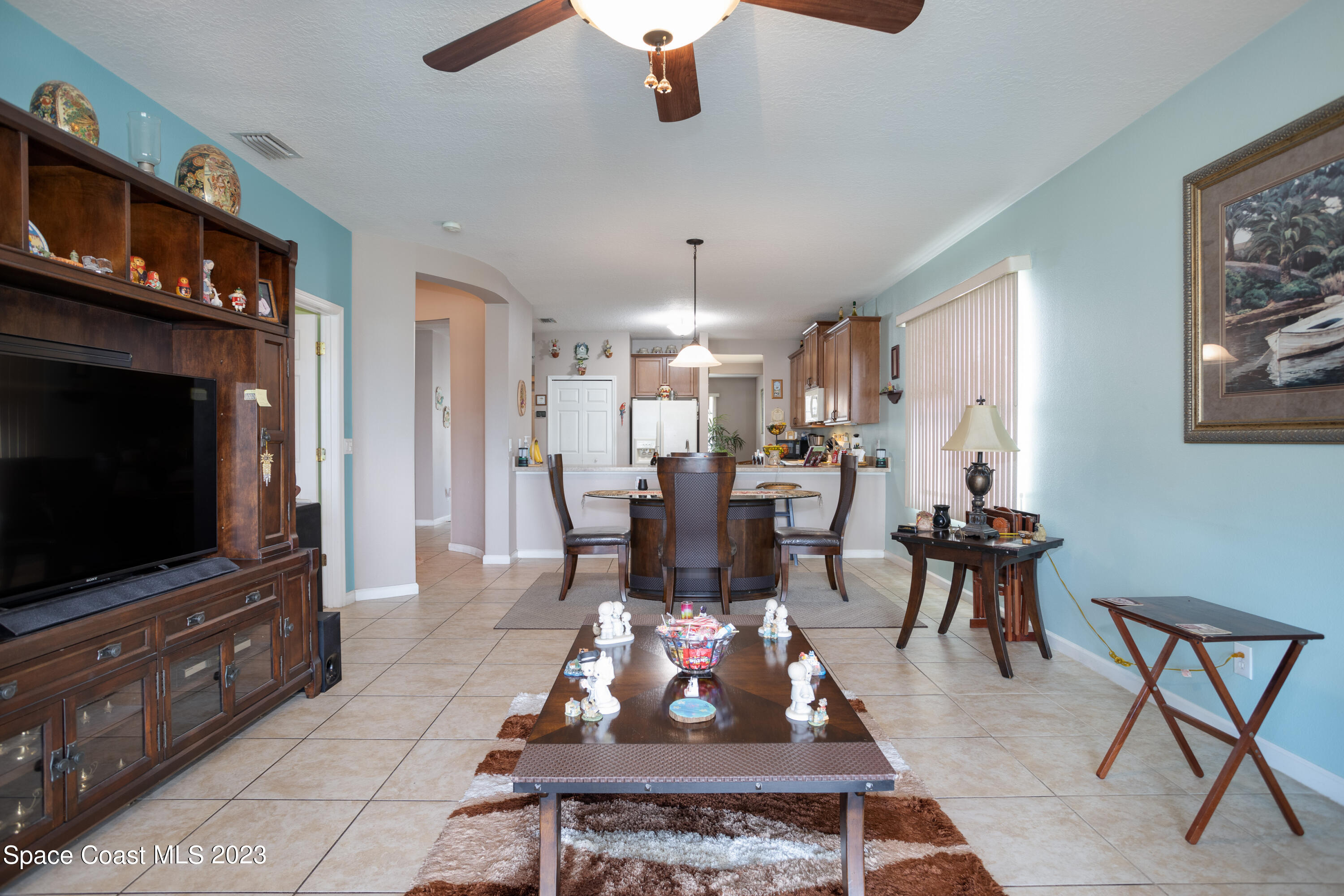 4130 Millicent Circle Melbourne, FL 32901 - Photo 15 of 28 a living room with furniture a flat screen tv and a dining table