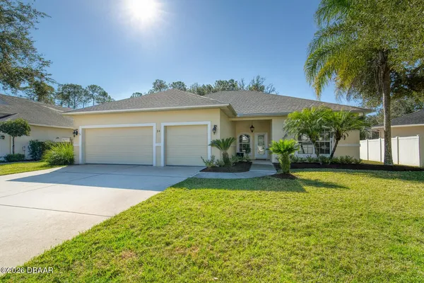 a view of a house with a yard and a garage