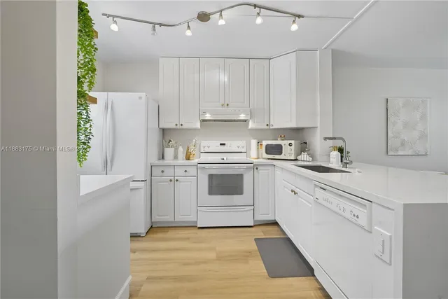 a kitchen with white cabinets and white appliances