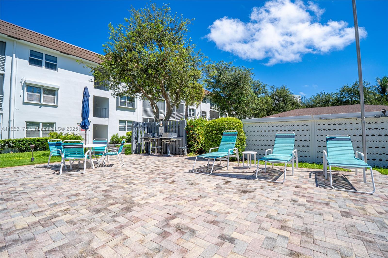 1501 South Ocean Boulevard, Unit 117 Lauderdale-by-the-Sea, FL 33062 - Photo 28 of 38 a lawn chairs and a table in a backyard