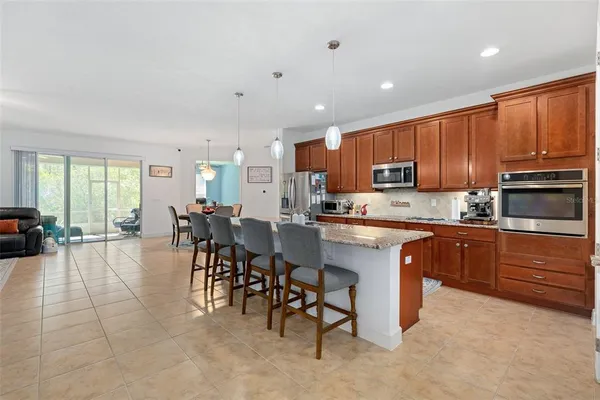a kitchen with stainless steel appliances kitchen island granite countertop a refrigerator and a stove top oven