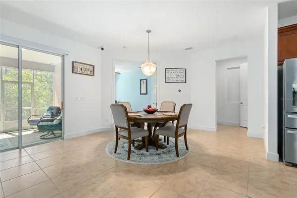 a living room with furniture a flat screen tv and a refrigerator
