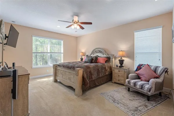 a spacious bedroom with a bed and a chandelier