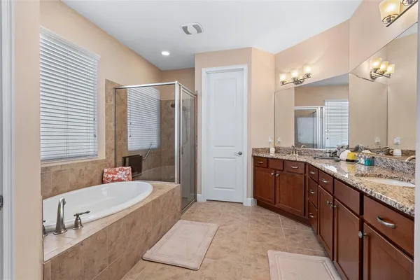 a spacious bathroom with a tub a window and a shower
