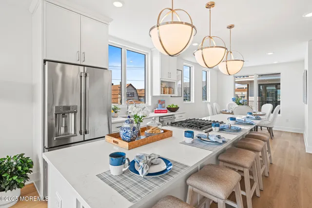 a very nice looking dining room with kitchen island furniture a large window and a wooden floor