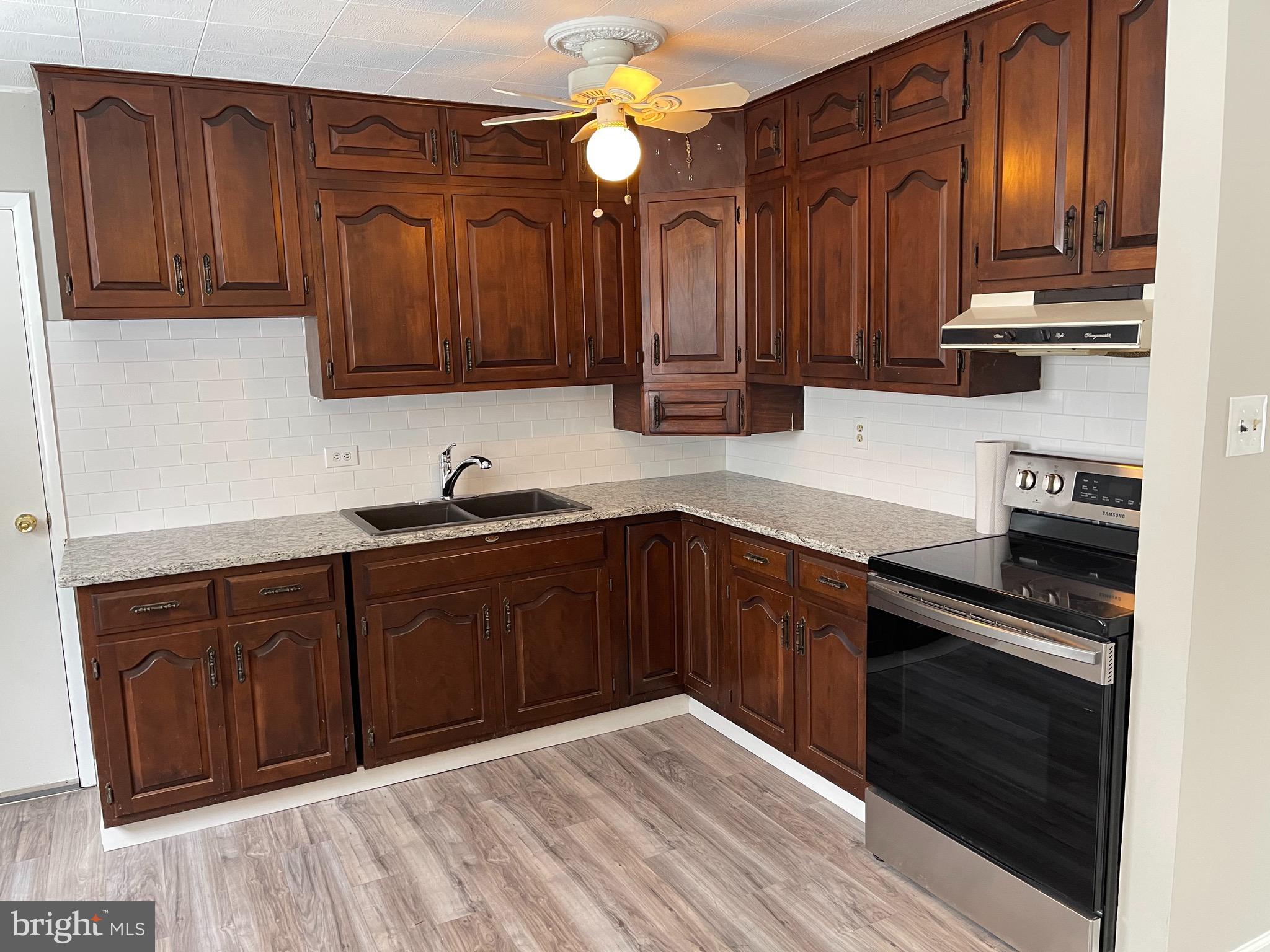 135 Garrett Road Newark, DE 19713 - Photo 11 of 32 a kitchen with stainless steel appliances granite countertop a stove a sink dishwasher and cabinets with wooden floor