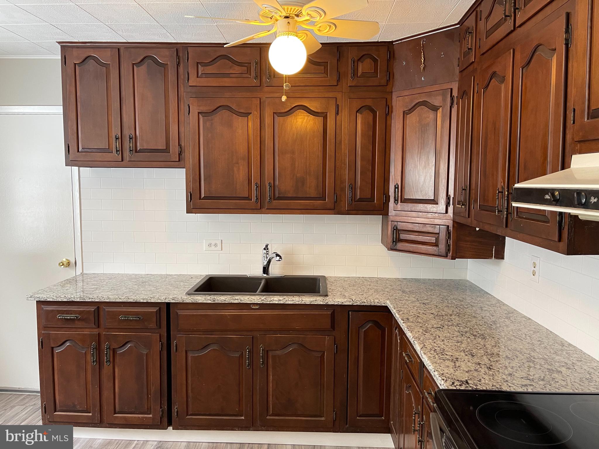 135 Garrett Road Newark, DE 19713 - Photo 10 of 32 a kitchen with granite countertop a sink dishwasher a stove and cabinets with wooden floor