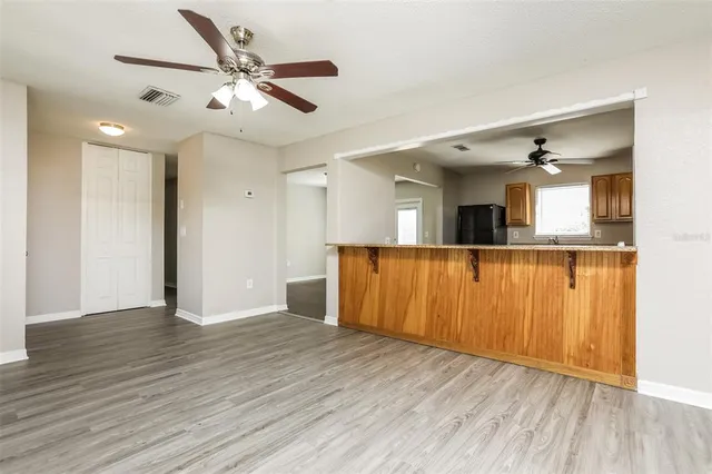a view of a kitchen with wooden floor and a ceiling fan